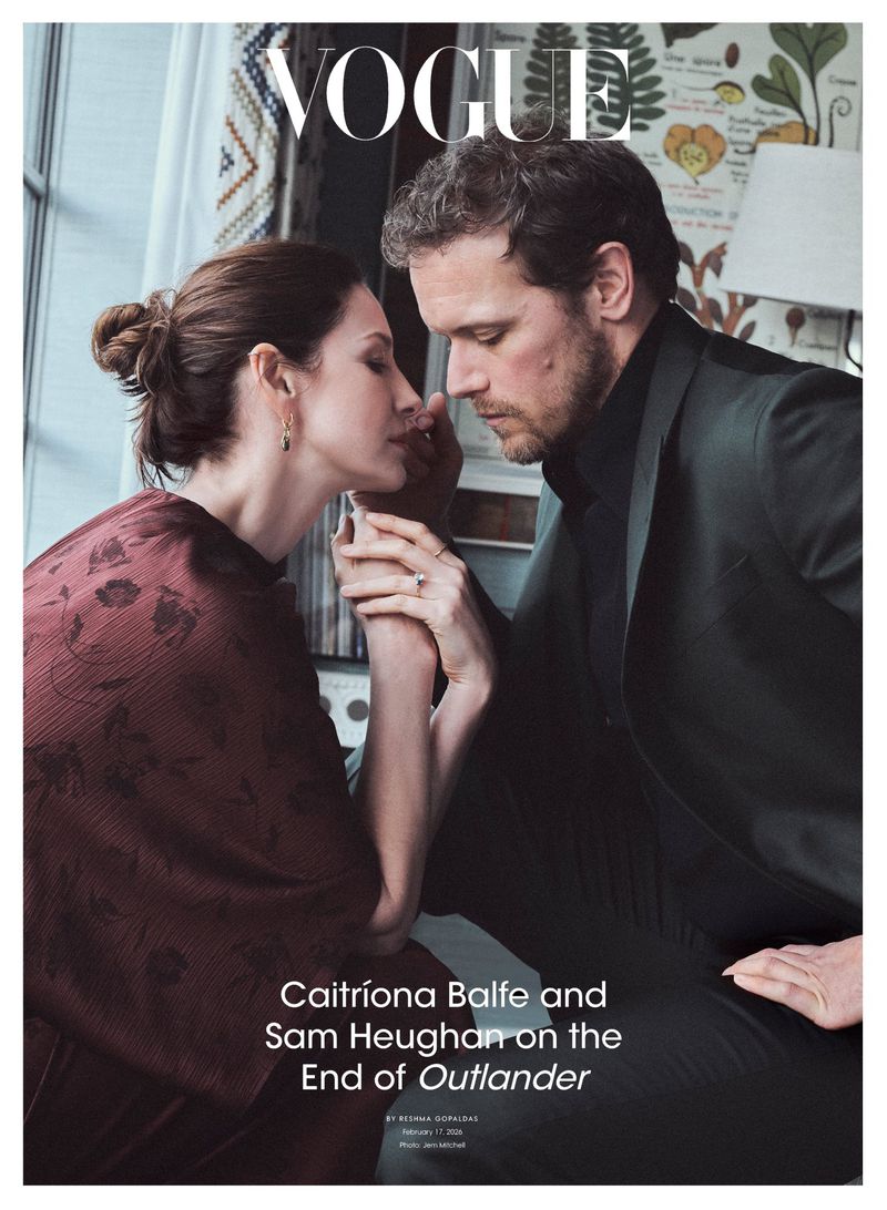Caitriona Balfe and Sam Heughan photographed together in a close-up shot; Vogue magazine cover, holding hands, dark green suit.