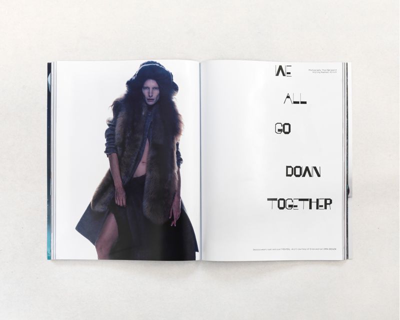 Editorial fashion photo on a magazine page featuring a slender woman in a fur vest, standing in front of a bright background and dark typography.