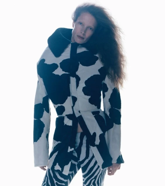 Fashion shot featuring a stylish adult female in an animal-print coat and pants against a stark white backdrop, creating a bold visual statement.
