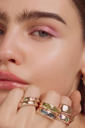 Close-up beauty portrait of a model wearing sparkling gemstone rings and soft pink eye shadow for InStyle Mexico