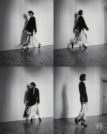 Woman in black top and flowing white skirt walks in a photo collage, with a light wall background, black heels, and indoor setting.