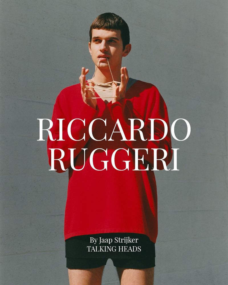 A young adult male poses in a red sweater against a grey wall, styled with rubber bands. Text reads 'Riccardo Ruggeri, By Jaap Strijker'.