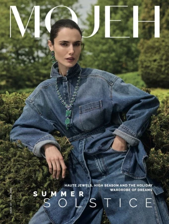 Magazine cover features a woman with dark hair and statement jewelry in a denim outfit, set against a green outdoor background.