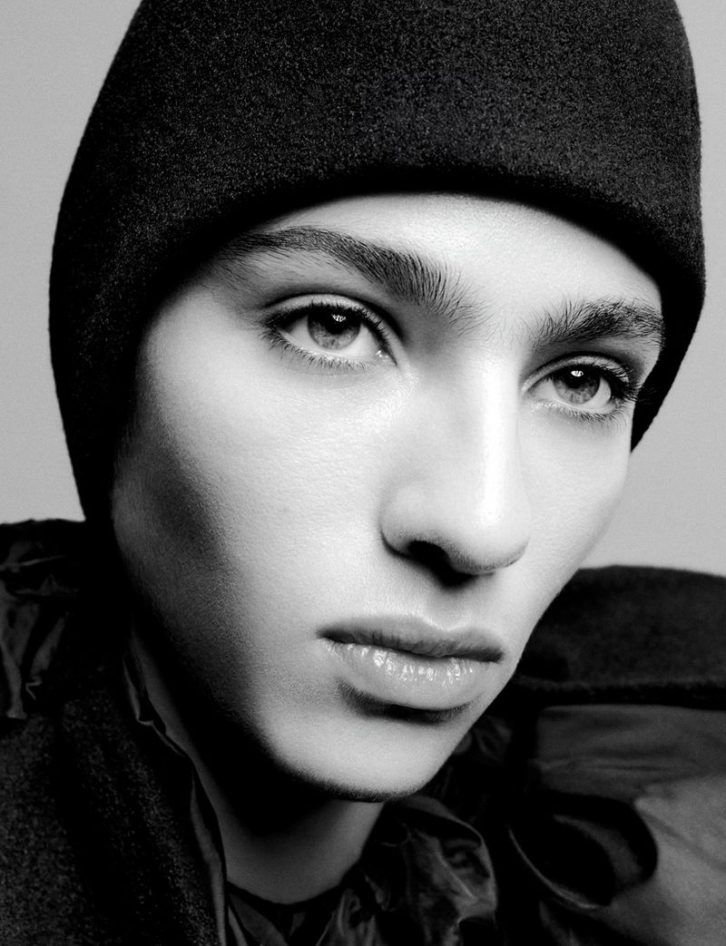 Monochrome portrait of an adult male with light skin wearing a dark hat and jacket, showcasing a serious facial expression.