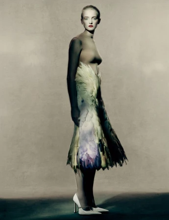 Woman in high heels wearing a dress made of feathers in a studio setting, artistic fashion photography. Neutral background, artful style.