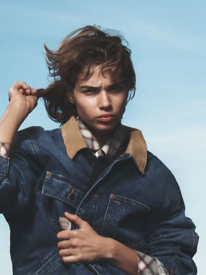 Model Mathilda Gvarliani wearing a denim jacket against a clear blue sky for W Magazine American Idyll project.