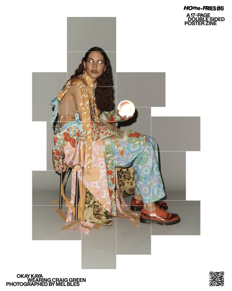 An adult female model sits in a photo studio wearing a patterned floral ensemble holding a glowing orb, showcased in a tessellated geometric frame.