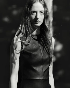 Monochrome portrait of a female model with long hair wearing a dark sleeveless top for Stouls Fall Winter 2026