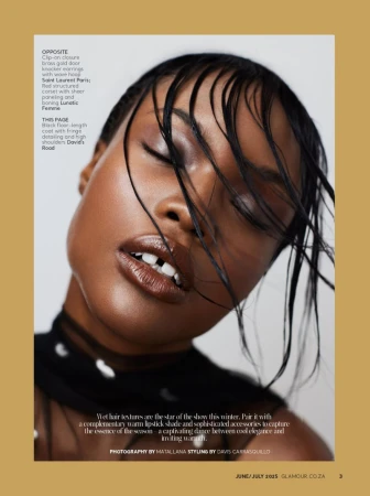 Close-up portrait of a dark-skinned female fashion model with wet hair, wearing a dark top with translucent fabric and a dark lipstick shade.