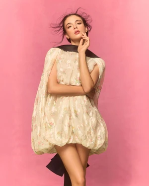 Model Deva Cassel posing in a floral balloon dress against a pink backdrop for Harper's Bazaar Turkey editorial