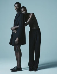 Two male models posing against a neutral grey studio background for Numero Homme Switzerland.