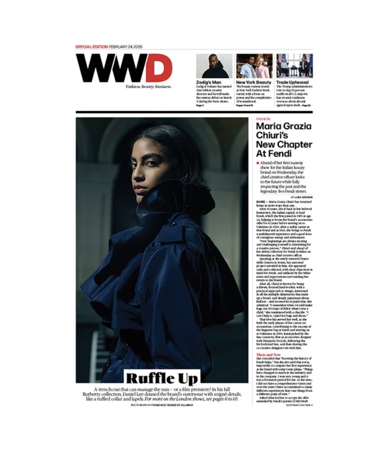 WWD cover features a stylish woman in a navy ruffled trench coat, fashion-forward design, and editorial layout with bold typography.