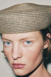 Close-up portrait of a woman wearing a structured woven straw cap for Zara Woman March 2026 photographed by Hanna Tveite.