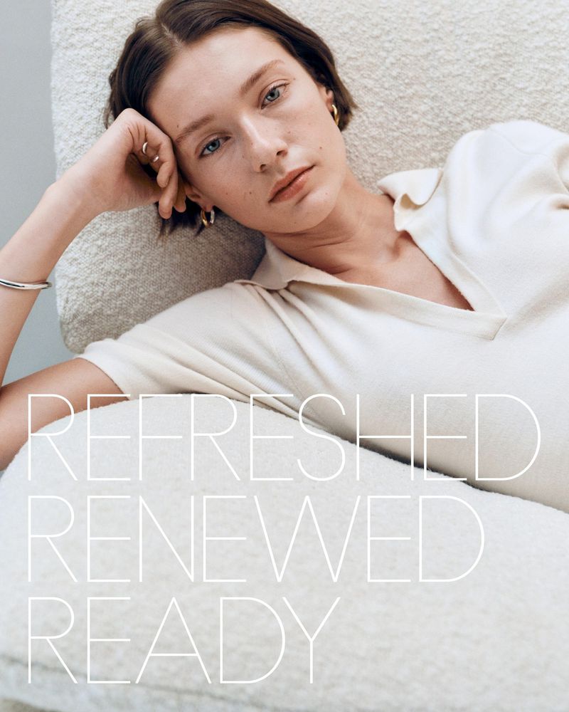 Young woman with short brown hair reclines on a cream-colored pillow wearing a white polo shirt, with white text overlay.