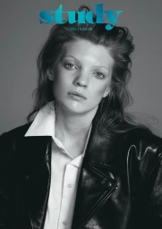 Monochrome portrait of a model in a black leather jacket and white button-down shirt against a grey studio background