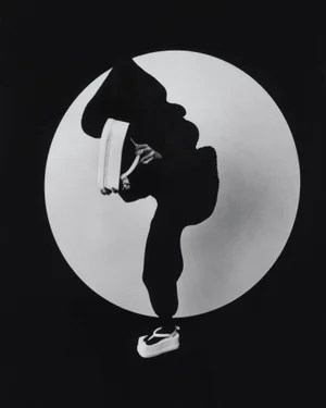 Model in silhouette wearing dark apparel and white platform shoes against a circular white backdrop for M Le magazine du Monde