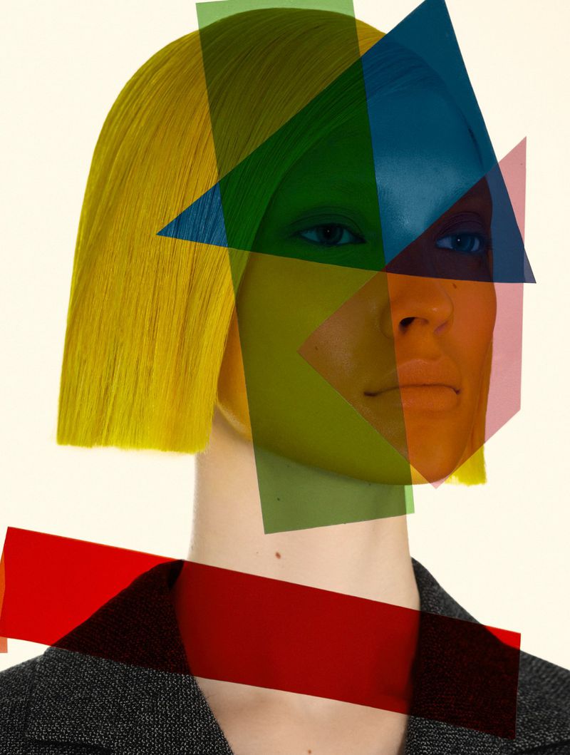 Woman with yellow hair and geometric color filters posing in a studio with a grey jacket and neutral background for a fashion editorial.