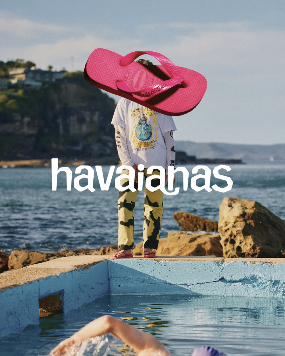 Promotional image of Havaianas flip-flops with a person in patterned pants, an ocean background, and someone swimming in a pool.