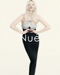 Model with long blonde hair wearing a black strapless gown with a sparkling crystal bodice against a white background.