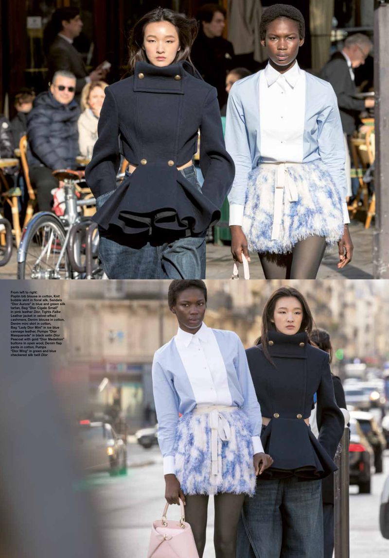 Two fashion models on city street wearing peplum jacket, skirt, button-down shirt, walking on the street with cars and buildings.