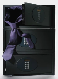 A purple necktie draped across three stacked black security safes against a light grey background.