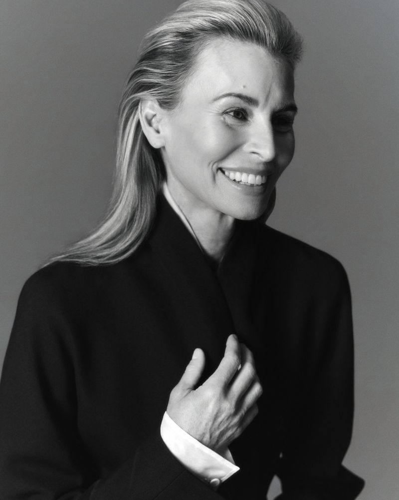 Portrait of model Niki Taylor smiling in a black jacket against a grey studio background for Harper's Bazaar Australia.