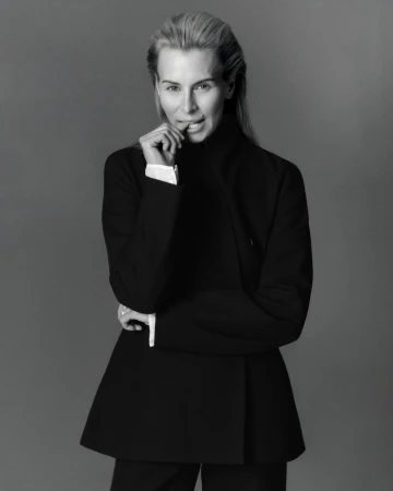 Model Niki Taylor wearing a dark jacket in a black and white portrait against a neutral grey studio background