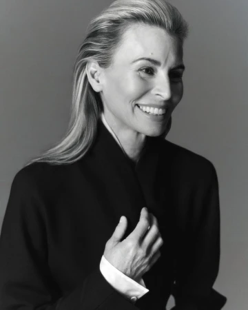 Portrait of model Niki Taylor smiling in a black jacket against a grey studio background for Harper's Bazaar Australia.