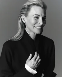 Portrait of model Niki Taylor smiling in a black jacket against a grey studio background for Harper's Bazaar Australia.