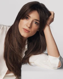 Close-up portrait of Daisy Edgar-Jones resting her head on her hand against a seamless white background for Estée Lauder.