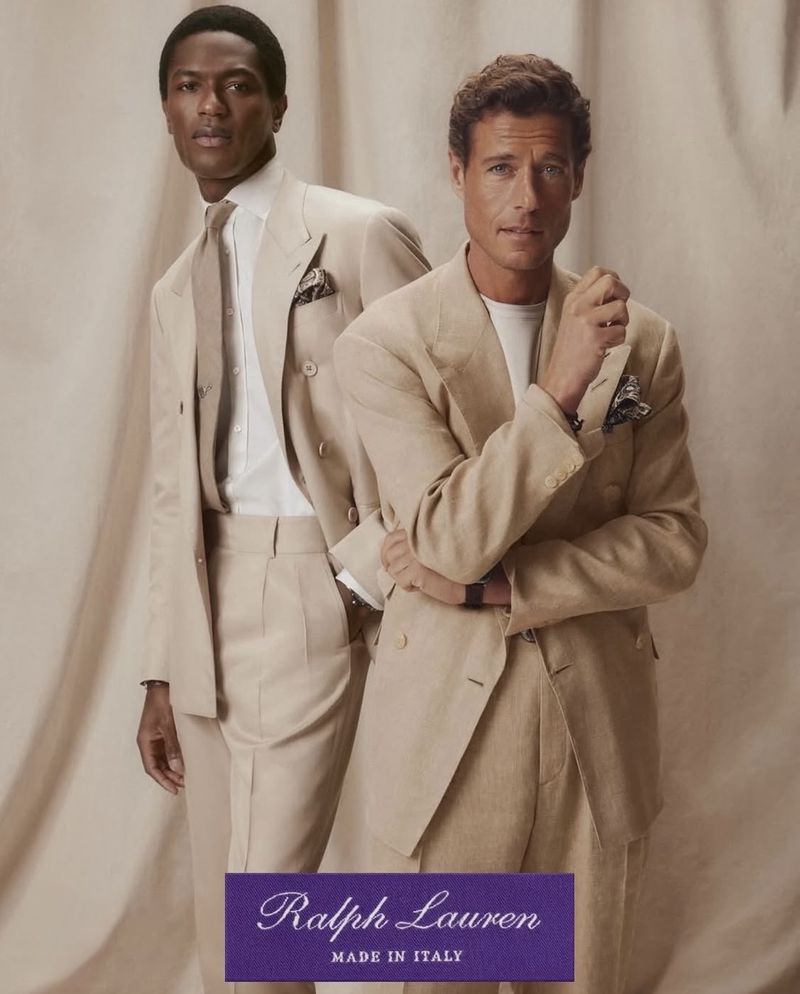 Two men in stylish tan suits pose in a studio setting against a neutral backdrop, featuring Ralph Lauren branding at the bottom.