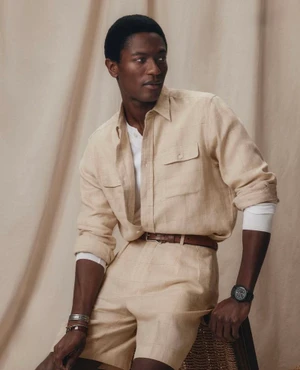 Model Hamid Onifadé in cream linen shirt and shorts with a brown belt by Ralph Lauren Purple Label