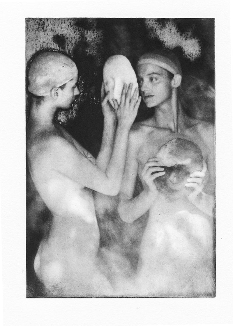 Monochrome fine art image of three people with anatomical face masks in a dark and textured environment with creative lighting.