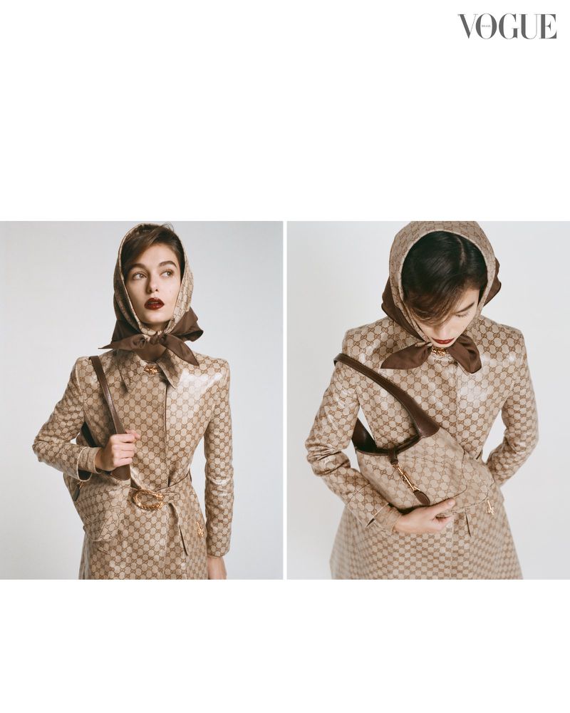 Fashion shot of a woman wearing a patterned trench coat, headscarf, and carrying a purse, photographed in a photo studio with 'Vogue' logo.