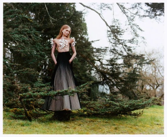 Model Ava Shipp in haute couture standing among pine trees for Vogue China editorial photographed by Javier Castán