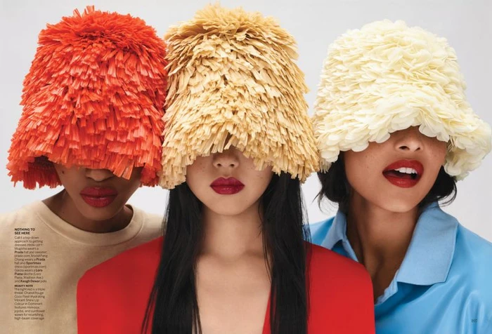 Three models wearing textured fringe bucket hats obscuring their eyes against a plain white studio background.