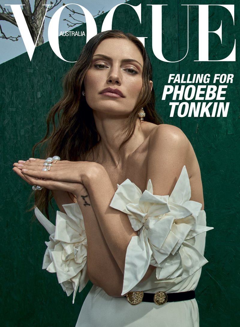 Vogue Australia cover featuring Phoebe Tonkin wearing a white dress with floral accents against a green backdrop, elegant jewelry.