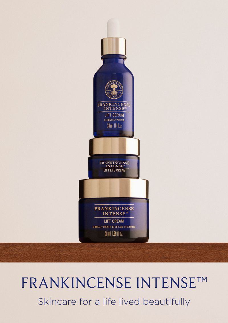 Stacked skincare products: Frankincense Intense Lift Serum, Lift Eye Cream, and Lift Cream in dark blue glass jars with silver lids.