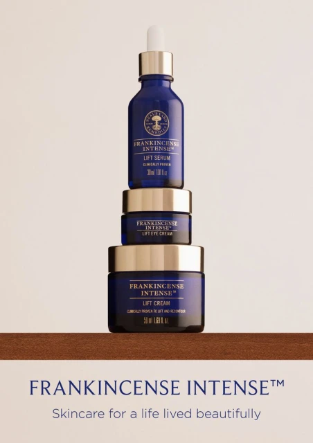 Stacked skincare products: Frankincense Intense Lift Serum, Lift Eye Cream, and Lift Cream in dark blue glass jars with silver lids.