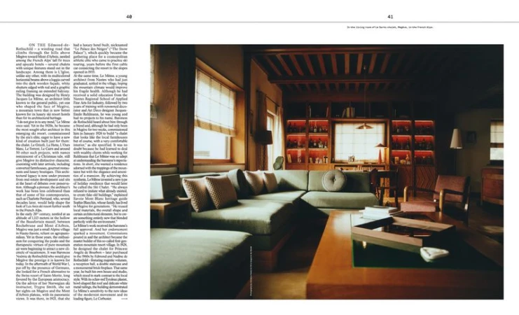 Warm interior of a living room with an olive green sectional sofa, wooden table, chairs, bookshelves, and natural light from windows.