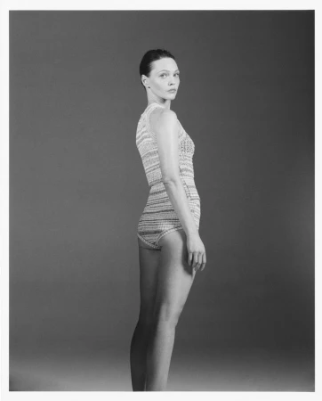 Model Sasha Pivovarova posing in a patterned swimsuit against a grey studio backdrop for W Magazine China.