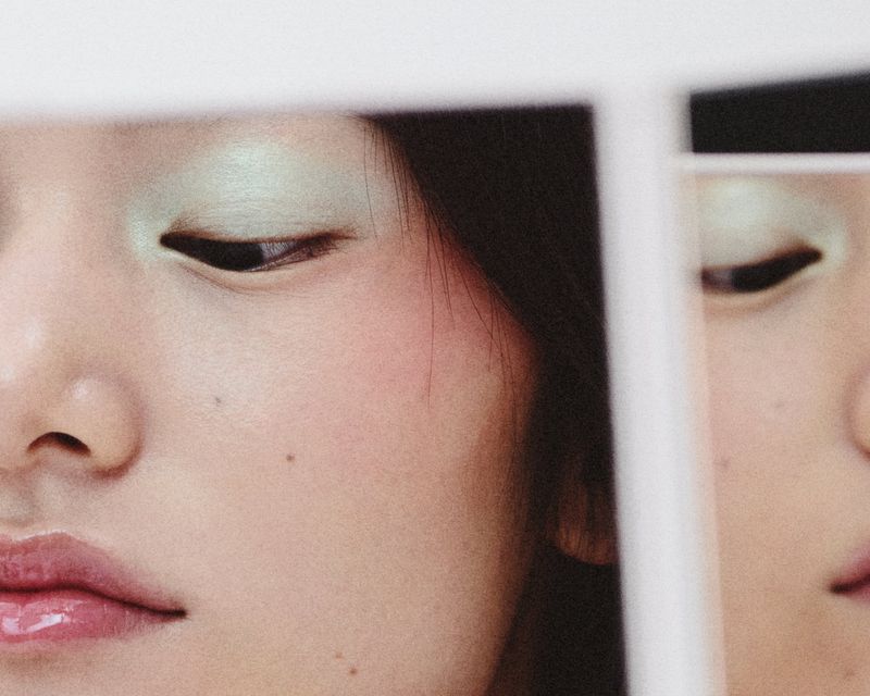 Close-up portrait of a fair-skinned adult female face with glossy lips and green eyeshadow, presented as a pair of images side-by-side.