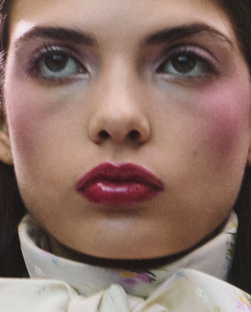 Close-up beauty portrait of a female model wearing glossy dark red lipstick and soft pink eyeshadow for Dior Beauty.