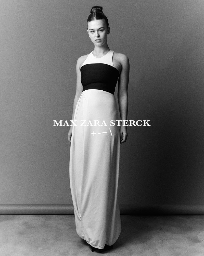 Elegant woman in a full-length dress posing in a studio setting, captured in a monochromatic portrait with clean lines and soft lighting.