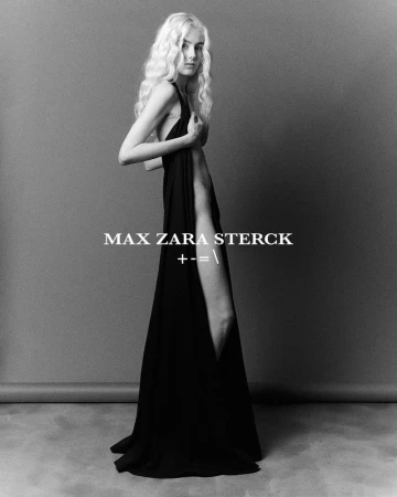 Blonde woman in a black gown poses in a studio. The monochrome shot features a semi-nude dress, studio lighting, and full body pose.