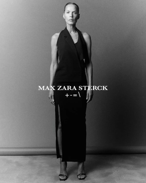 Elegant woman in black top and high-slit skirt strikes a pose in a monochrome studio portrait. Formal attire, full body shot, minimalistic.