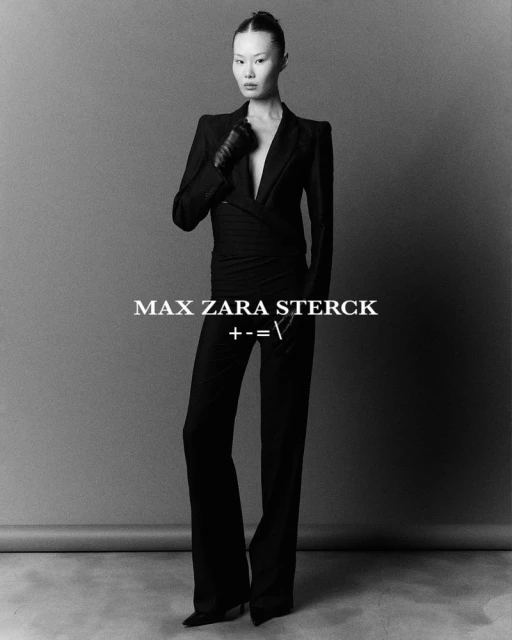 Elegant Asian woman in a stylish black suit poses in a studio. A fashion shot with artistic text overlay and neutral grey background.