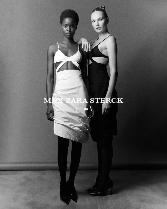 Two fashion models wearing contrasting white and black outfits posing together in a studio setting.