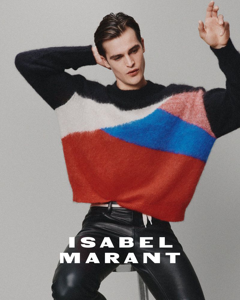 Man wearing a colorblocked sweater and black leather pants against a grey seamless background for Isabel Marant.