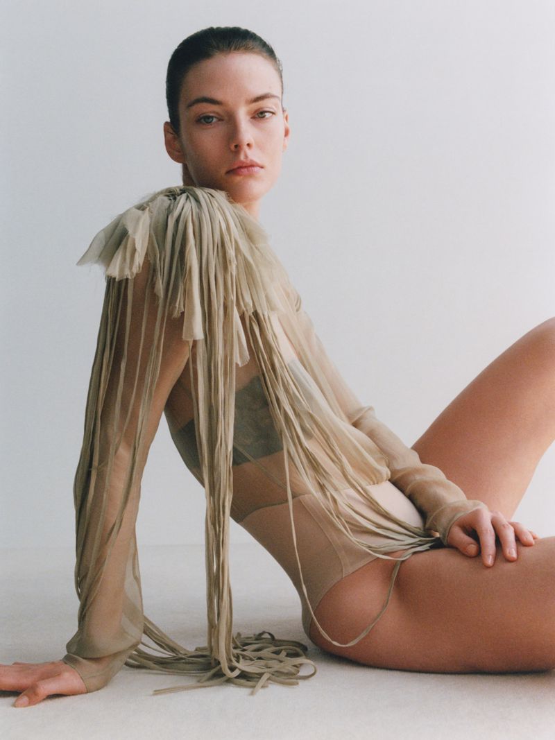 Model seated wearing a sheer fringe top against a neutral studio background for The Gentlewoman.